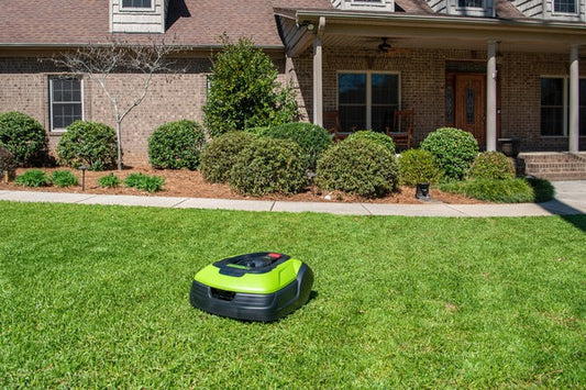 A Greenworks robotic lawn mower on grass.
